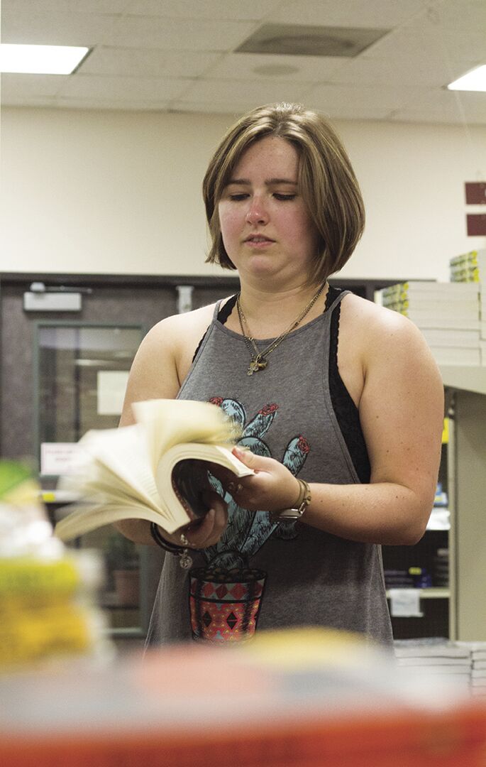 Magen Huntley, theater freshman, flips through her future phycology book Aug. 21 at the Textbook Store.
Photo by Hannah Felske