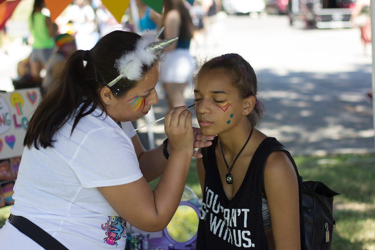 Natalie Ponce applies Pride-themed face paint for Maya Rose Sept. 9 at her booth during SMTX Pride. The event was located downtown at Plaza Park.Photo by Lara Dietrich
