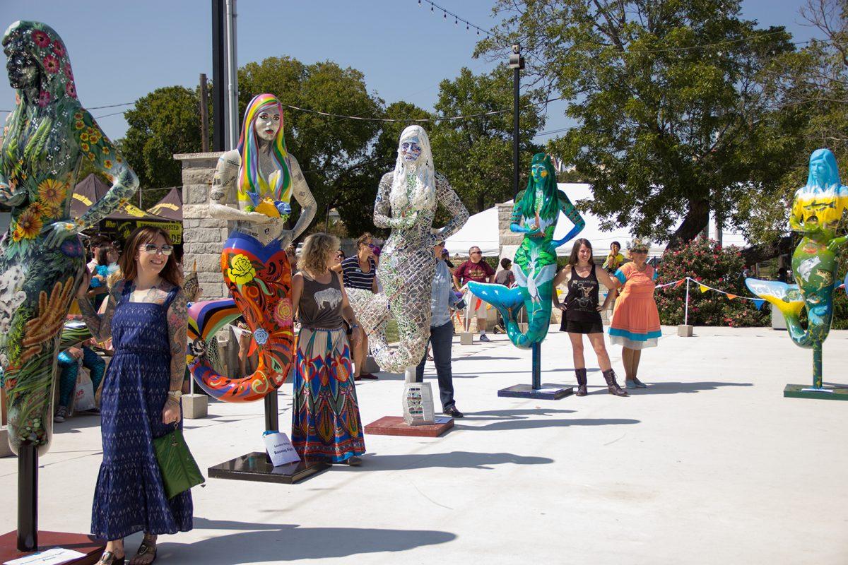 Artists stand near their mermaid creations Sept. 16 during the unveiling of the ten new statues at the Aqua Faire, held at San Marcos Plaza Park. The statues are to be placed alongside the river, as well as various locations throughout San Marcos.Photo by Lara Dietrich | Multimedia Editor