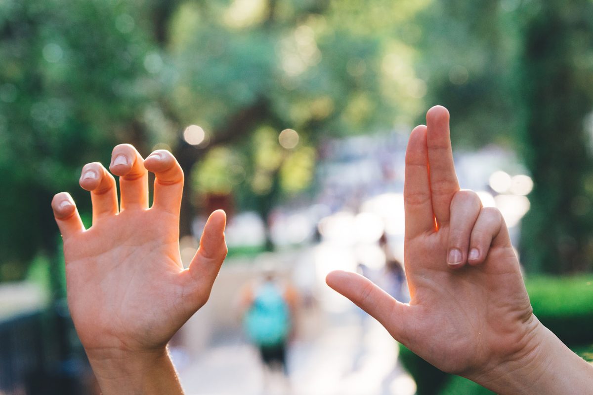 A student holds up the official Texas State hand signs Sept. 13 in the Quad. The Heart of Texas Hand Sign is supposed to resemble the shape of Texas, with the two outside fingers pointing at the location of the university.Photo by Kirby Crumpler | Staff Photographer