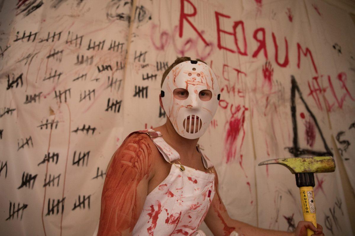 A masked man stares at haunted house victims Oct. 29 during the second annual Phi Kappa Psi and Delta Zeta haunted house.Photo by Felipe Gomez | Staff Photographer