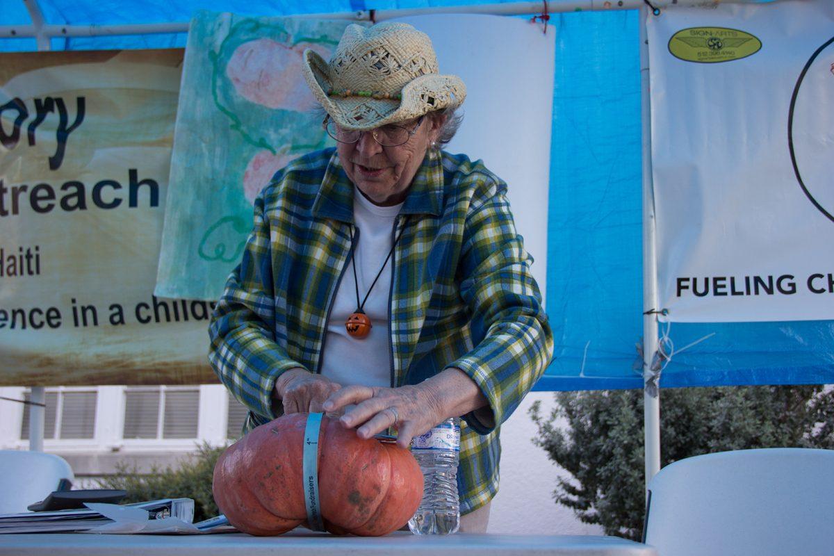 Lou-Marie Heath, pumpkin patch chairman, measures the width of a pumpkin Oct. 26 at First United Methodist Church. The price of the pumpkins is determined by their size, and all of the proceeds are donated to different charities.Photo by Lara Dietrich | Multimedia Editor
