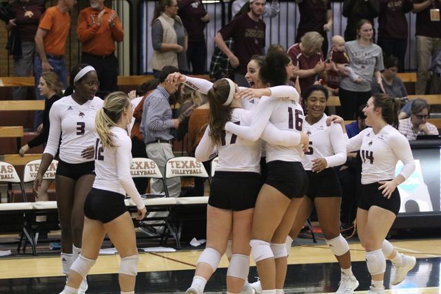 Volleyball team celebrates after the final set wi in Gregory Gym. Photo by Kate Connors