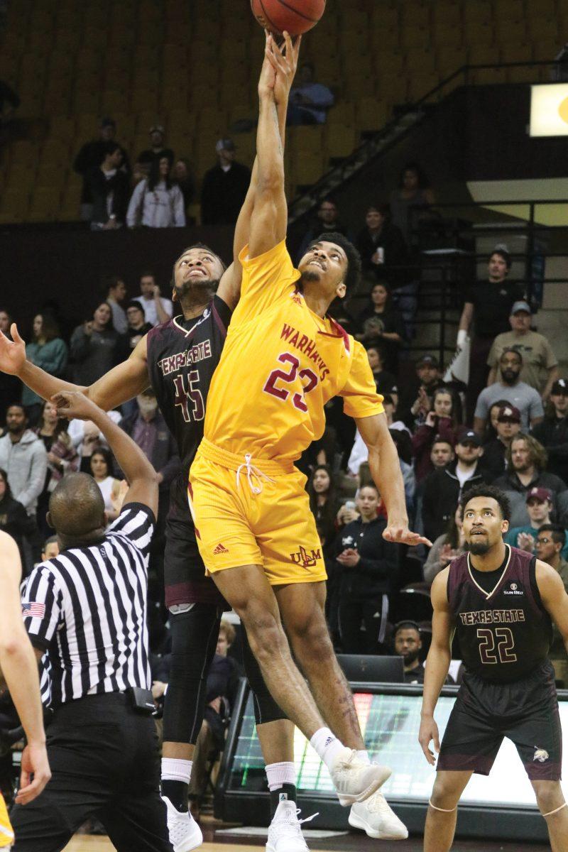 Forward Eric Terry competes against ULM forward Youry White for the basketball to tip-off the Feb. 21 basketball game. Photo by Kate Connors.
