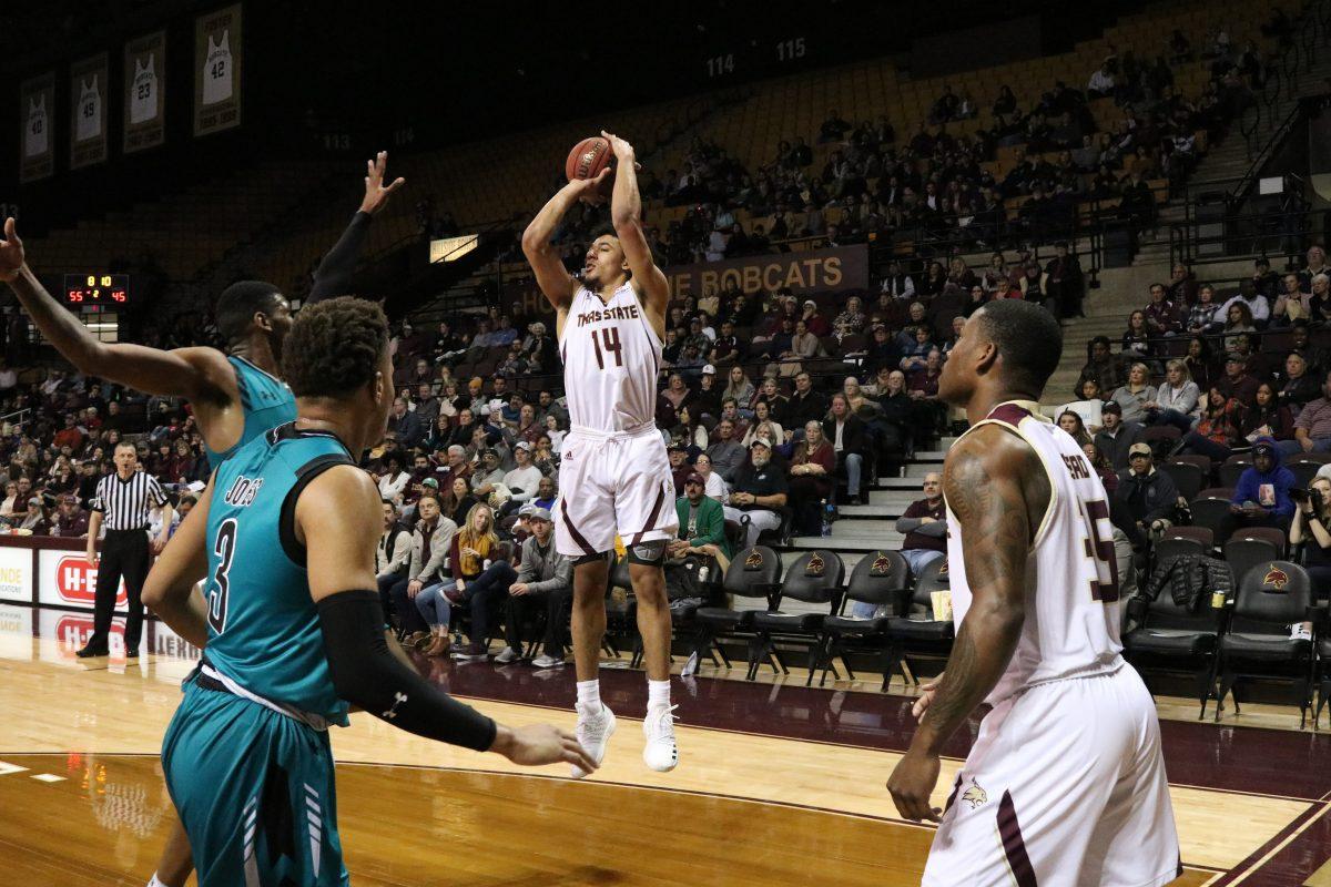 Sophomore, Quentin Scott, shoots a basket in the Feb. 9 game against Coastal Carolina. Photo by Kate Connors