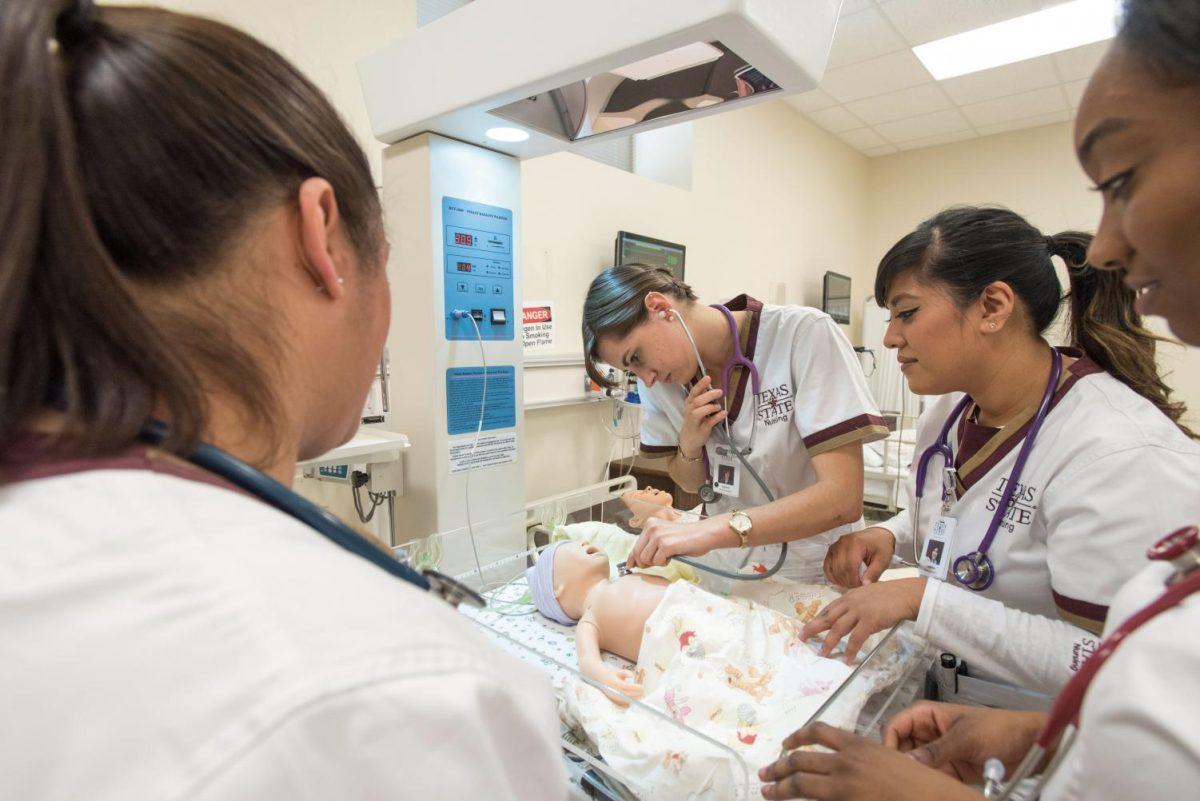 Nursing students check and react to the heart beat of an infant simulator at the Texas State University Round Rock Campus.