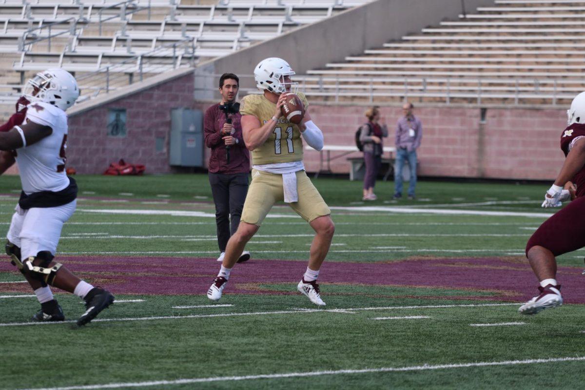 Sophomore quarterback Tyler Vitt scans the field for an open receiver April 13 during the spring football game. Photo credit: Kate Connors
