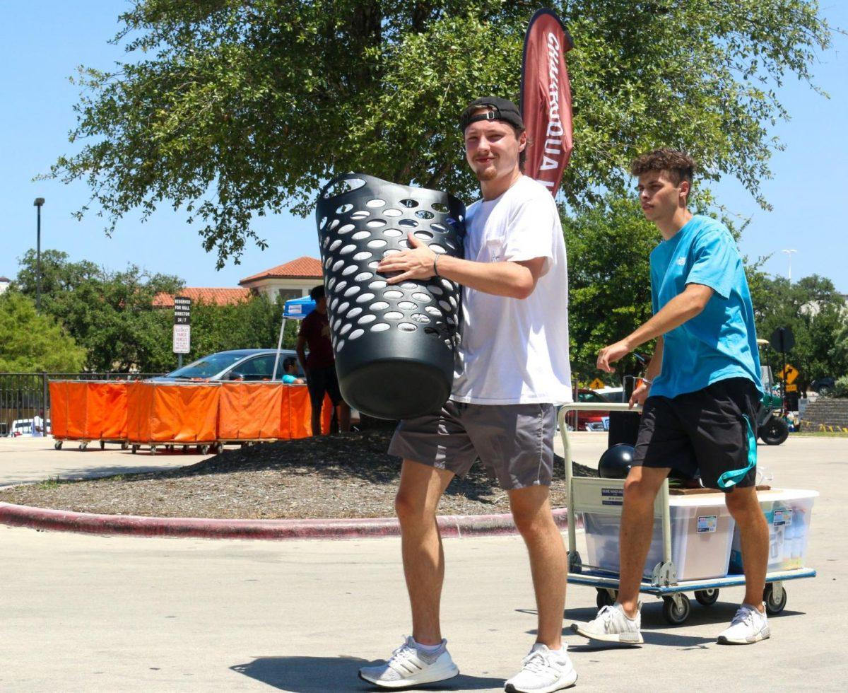 Incoming freshmen Chase Toupal (left) and Hunter Conway walk their belongings into Gaillardia and Chautauqua Hall on Aug. 17 on Student Center Drive. Photo credit: Jaden Edison
