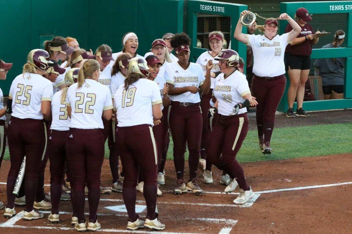 The Bobcats rush around home base to celebrate freshman Sara Vanderford’s home run hit during the game against St. Mary’s Oct. 18. Photo credit: Kate Connors