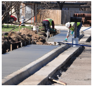 Construction workers leveling out cement as part of San Marcos’ Five-Year Sidewalk Maintenance and Gap Infill Plan.