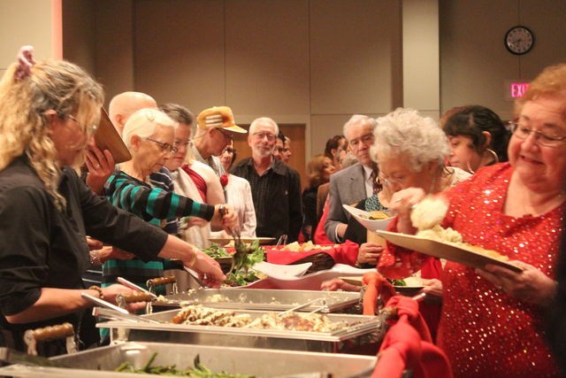 Guests serve themselves food catered by The Root Cellar Cafe & Brewery during the Golden Sweetheart’s Ball, Friday, Feb. 14, 2020, at the San Marcos Activity Center.