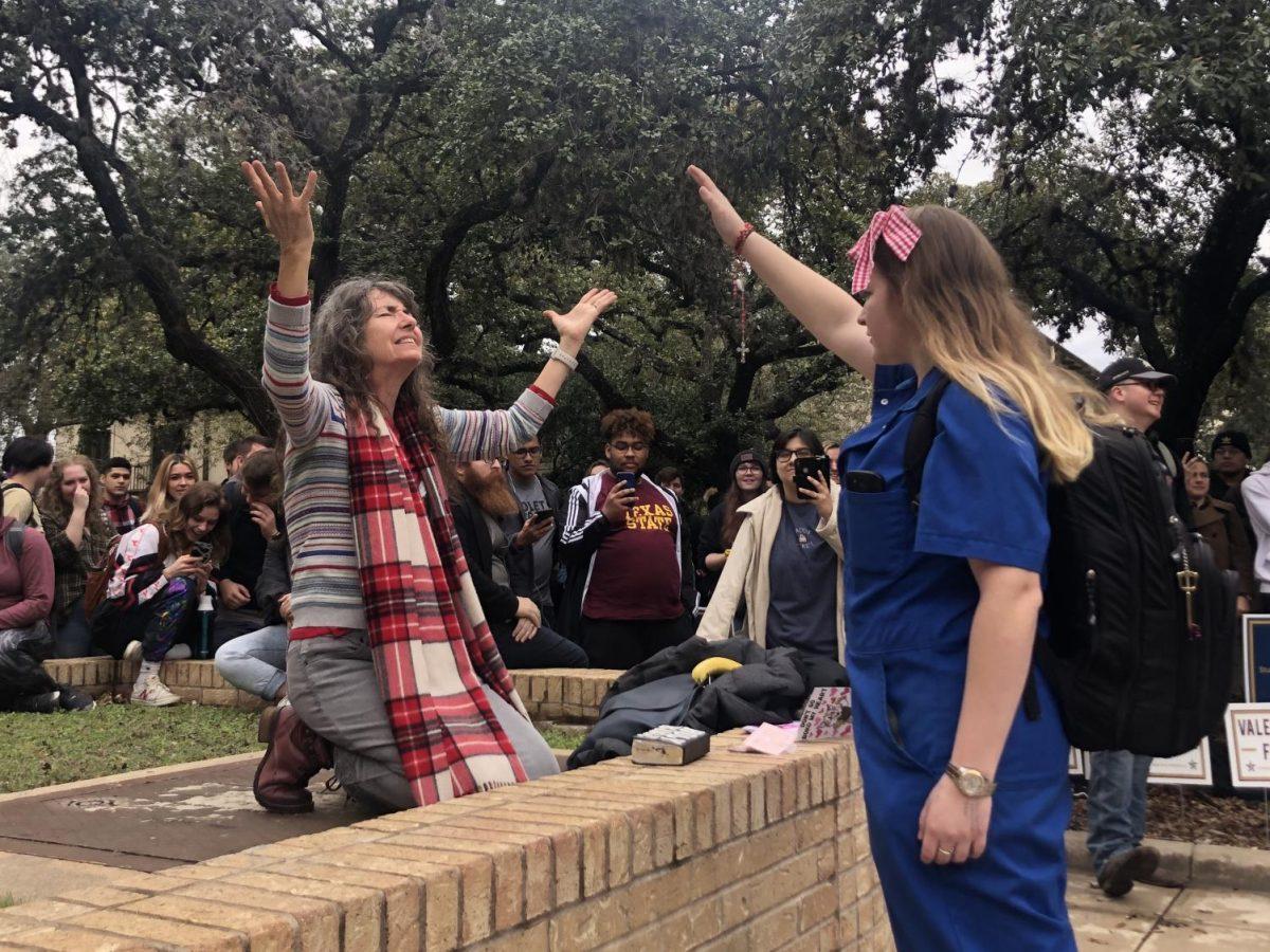 Texas State student Imogene Daily (right) raises a hand in prayer over preacher “Sister Cindy” Smock (left) as she prays for repentance Wednesday, Feb. 12, 2020, in the Quad.