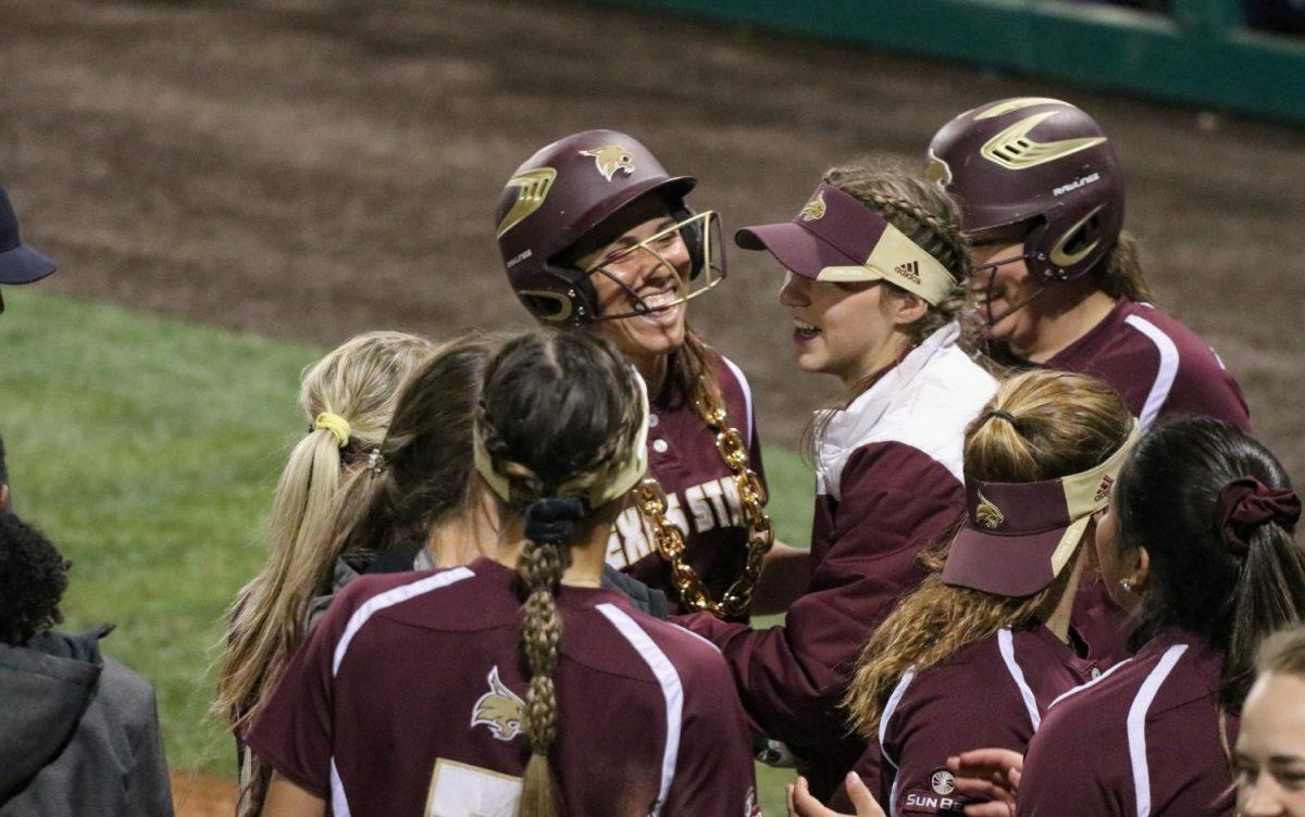 The Texas State softball team rushes to home plate to congratulate teammate Christiana McDowell for hitting a home run in the sixth inning against Saint Louis, Friday, Feb. 14, 2020, at Bobcat Softball Stadium.