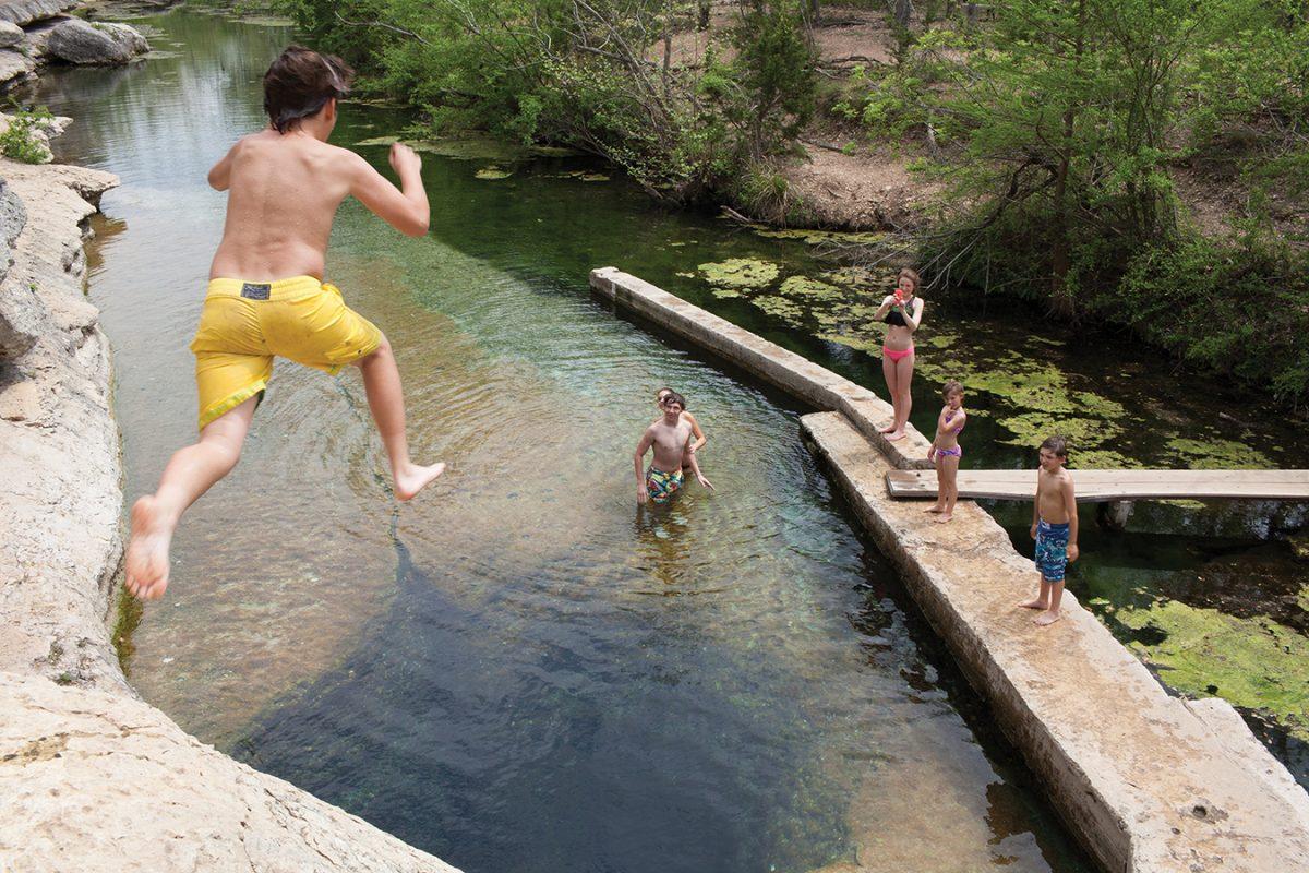 Photo by:Preslie Cox | PhotographerLuke Timms, Georgia resident, jumps into Jacob’s Well April 6 in Wimberley.