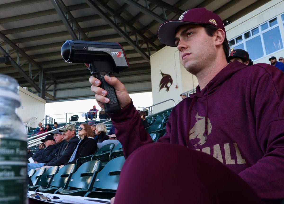 Texas State economics junior Jacob Millender uses a speed sensor to measure and record the speed of a baseball after it is pitched, Saturday, March 3, 2020, during the Texas State vs. Bethune Cookman at the Bobcat Ballpark.