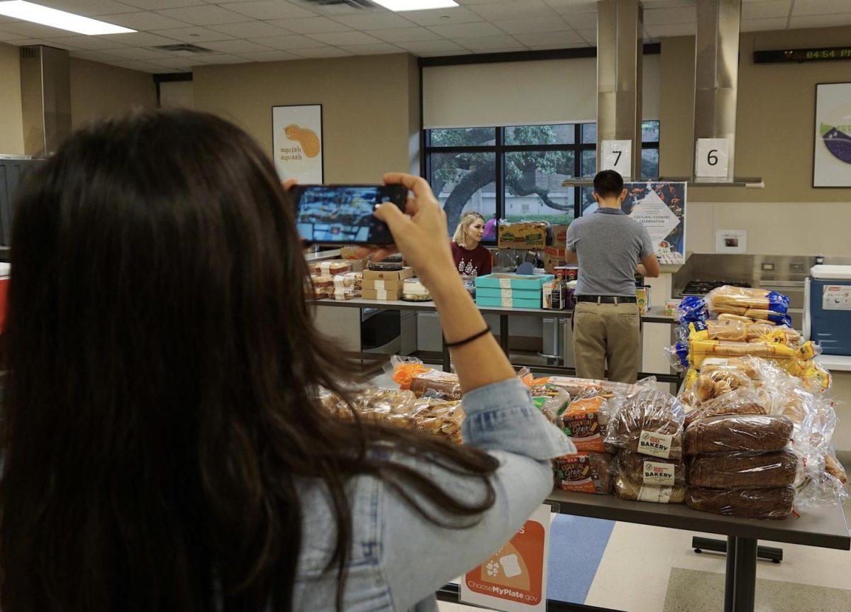 Nutrition and dietetics student Katie Dalpiaz takes photos of the Bobcat Bounty food pantry Thursday, October 24, 2019, in the FCS building where the pantry is usually hosted every Thursday. What once was a walk-in pantry now requires recipients to sign up in advance online or by email. Photo credit: Rebecca Harrell