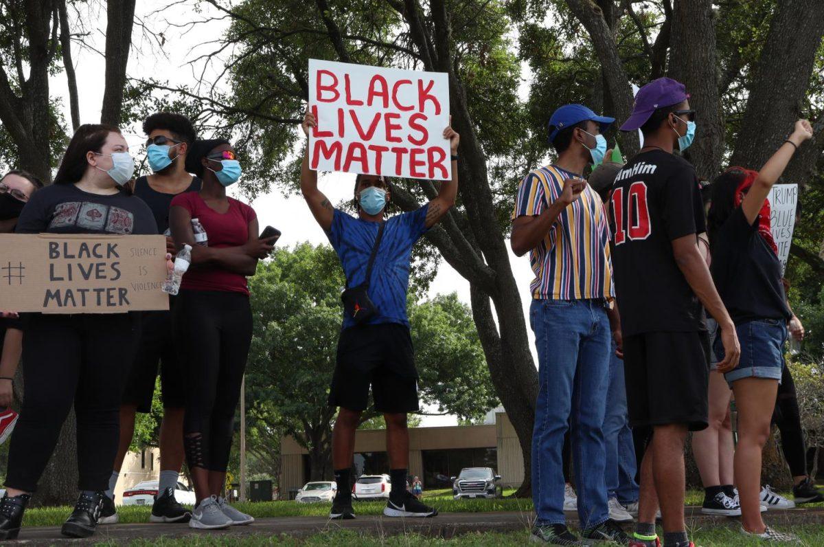 Texas State graduate Ty Fromme holds a sign on Hopkins Street near San Marcos City Hall, Friday, May 29, 2020, in San Marcos. The organized protest called for justice for George Floyd and Breonna Taylor.