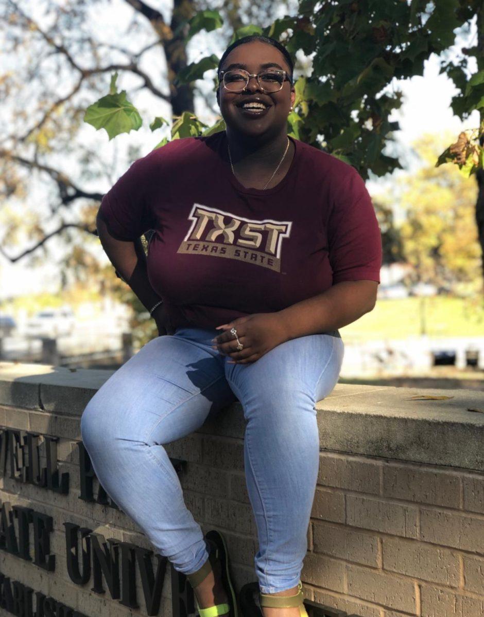 Marketing graduate Ahkilah Armster smiles for graduation photos near Sewell Park at Texas State University. Armster plans to enroll in Texas State’s Marketing Research and Analysis master program. Photo courtesy of Ahkilah Armster