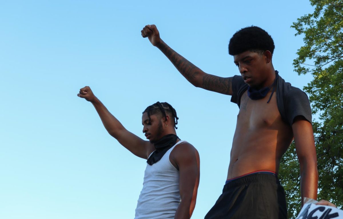 (Left to right) Mhyson Williams and Javien Buffin hold their fists in the air while standing on the roof of a parked car, Friday, June 5, 2020, at an organized protest advocating for black lives.