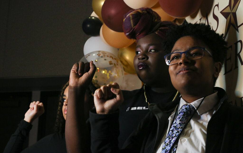 (Front to back) TeraLynn Steele, Breana Miller and Najha Marshall hold their fists up, a gesture symbolic of unity and solidarity in black communities, while getting their photo taken, Tuesday, Jan. 21, 2020, at the 36th Annual MLK Commemoration Celebration in the LBJ Ballroom.