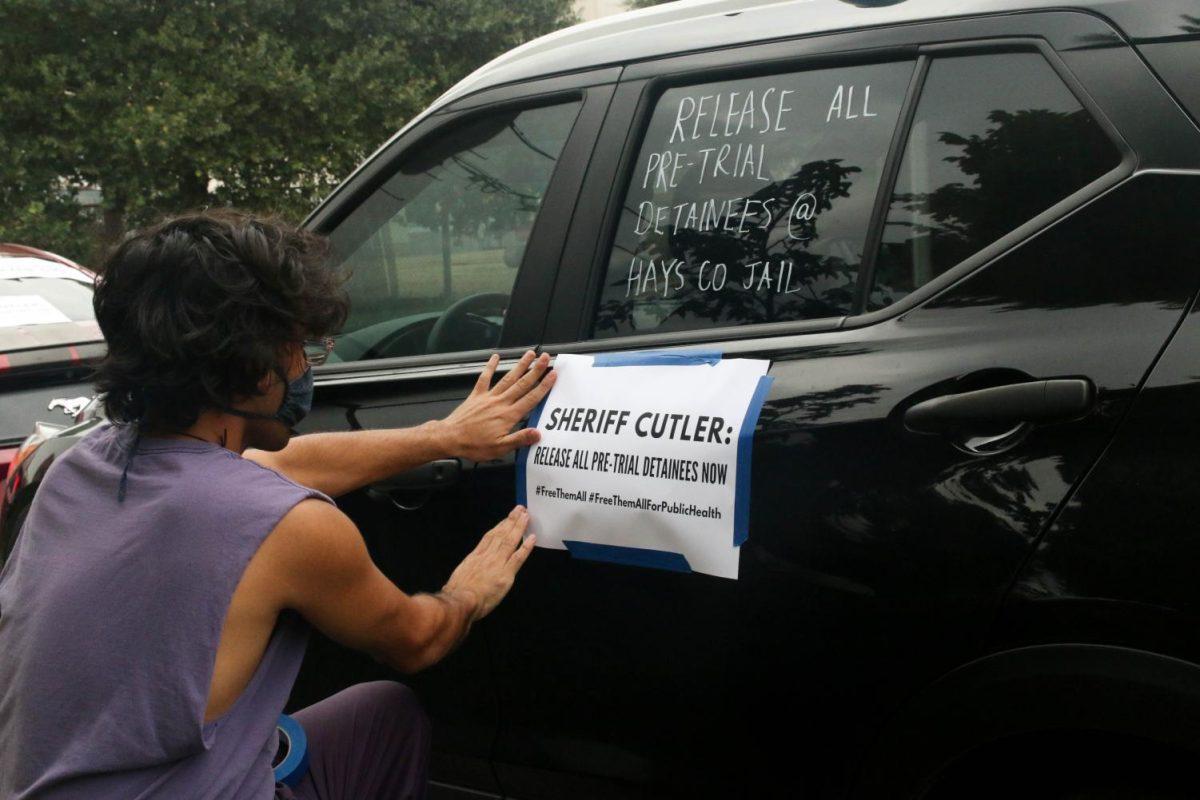 Jose Dominguez-Leal tapes a piece of paper calling for action from Hays County Sheriff Gary Cutler, Tuesday, June 30, 2020, on Martin Luther King Drive in San Marcos. (Jaden Edison)