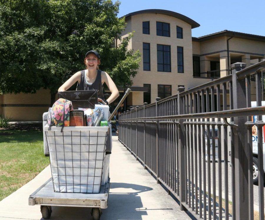 In this file photo, incoming freshman Abby Cooper rolls her belongings on a cart into Gaillardia and Chautauqua Hall, Saturday, Aug. 17, 2019, on Student Center Drive at Texas State.