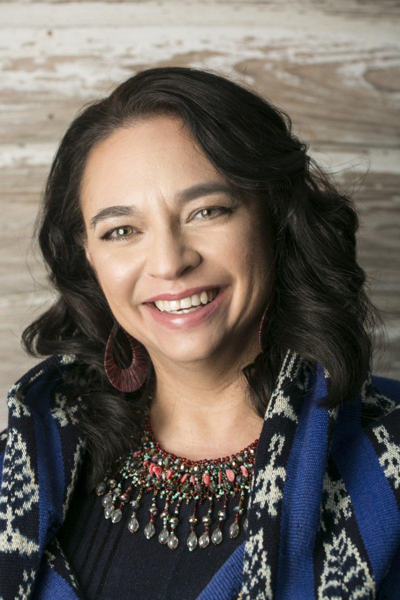 Diana López smiles for a headshot image. López earned her MFA from the creative writing program at Southwest Texas State in 1999. Since then, she has published several books and has won numerous literary awards.