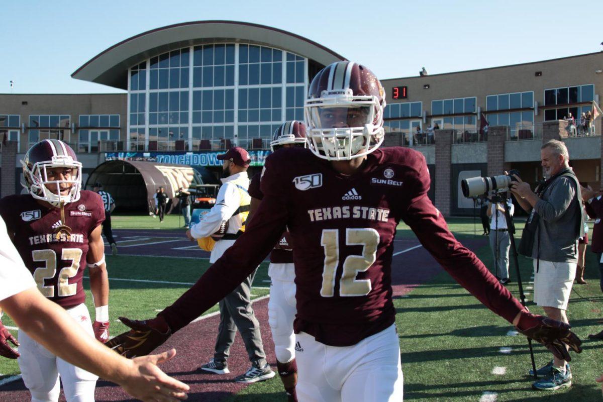Wide receiver Javen Banks high fives coaches and fans on the sidelines after scoring a touchdown, Saturday, Nov. 9, 2019, during Texas State’s homecoming football game vs. South Alabama at Bobcat Stadium.