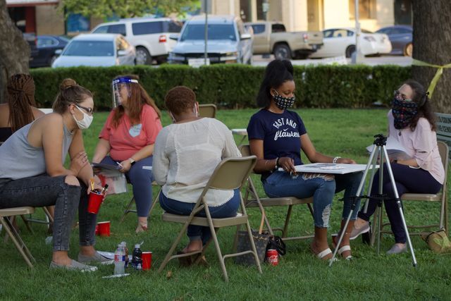 Attendees work on painting their canvases while their respective trained volunteers sit with them and offer support during the Love Canvas event, Saturday, Sept. 26, 2020, outside the Hays County Historic Courthouse.