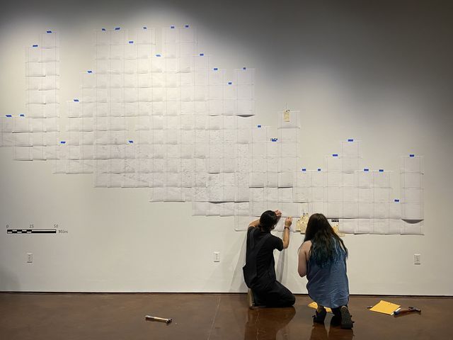 Members+of+Texas+State+Galleries+pin+yellow+toe+tags+marking+the+location+where+a+migrant+lost+their+life+while+traveling+through+the+Sonoran+Desert+at+the+Hostile+Terrain+94+installation+inside+Texas+State+Galleries.+Exhibit+visitors+are+invited+to+fill+out+toe+tags+with+the+personal+information+of+a+person+who+died+while+migrating.+%28Photo+courtesy+of+Margo+Handwerker+%29