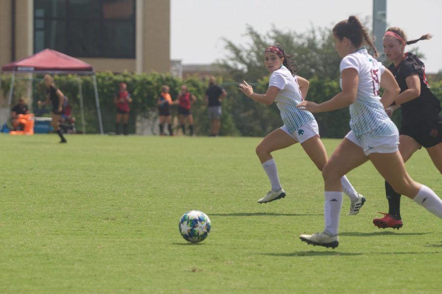 Texas State junior midfielder/forward Ally Kewish (12) and freshman forward/midfielder Haley Shaw (19) work together to get the ball down the field while University of Louisiana at Lafayette junior forward Lizzie Mayfield (22) is close behind, Sunday, Sept. 20, 2020, at the Bobcat Soccer Complex. Photo credit: Michele Dupont
