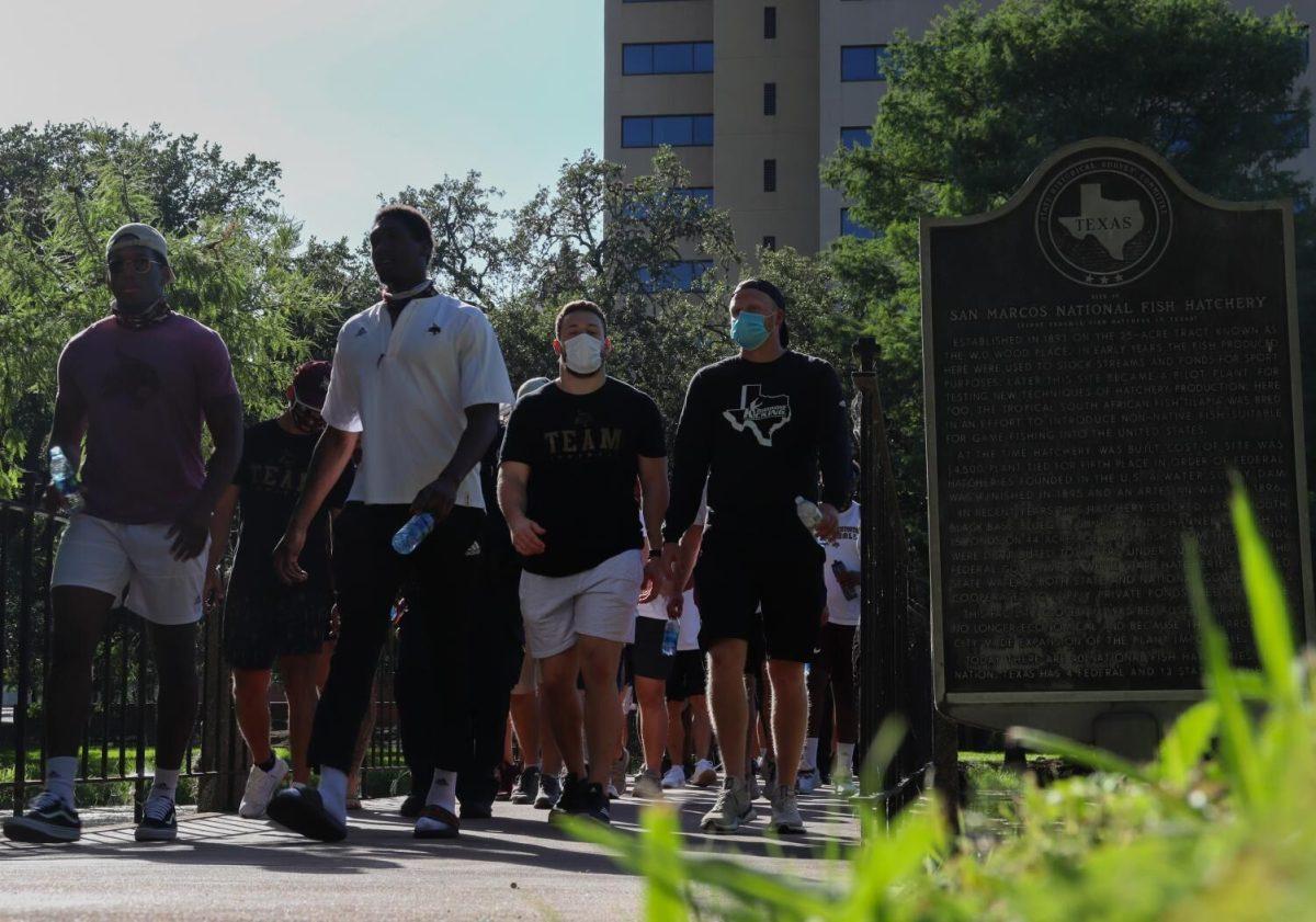 Attendees of a unity march put on by the Texas State Athletics Department walk across the San Marcos Fish Hatchery, Friday, June 10, 2020, outside of the J.C. Kellam Administration Building. Officers from the University Police Department as well as the San Marcos Police Department were present and marched alongside athletes.