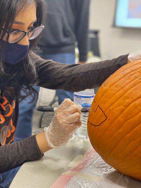 Texas State international relations senior Karla Vargas carves a pumpkin for the first time, Saturday, Oct. 31, 2020, at the Koinonia Halloween Hangout at the LBJ Student Center.