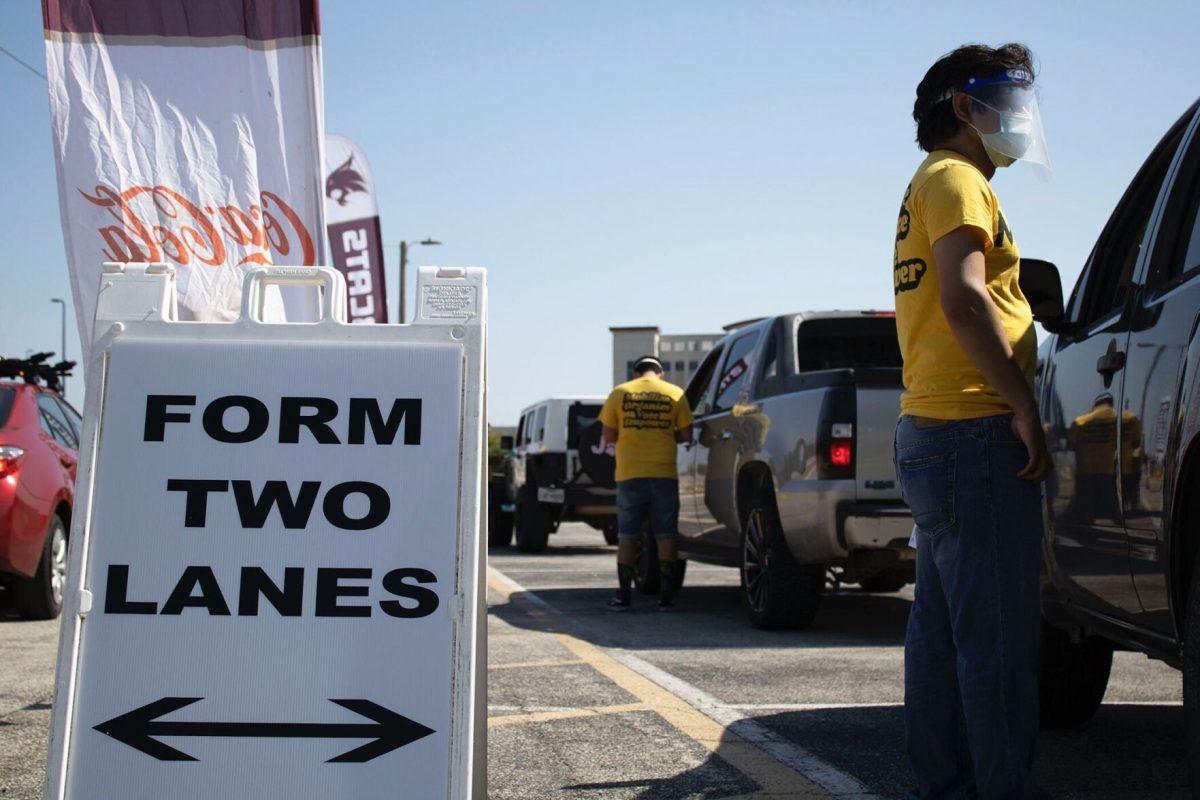 Texas Rising volunteers line up cars to help citizens register to vote during a drive-in voter registration hosted by Texas State Athletics, Monday, Oct. 5, 2020, in the Strahan Arena parking lot.