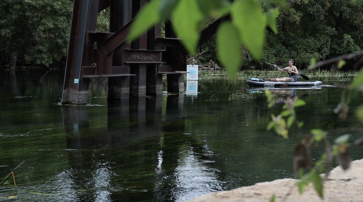 A woman paddles down the crystal clear water of the river in San Marcos. 