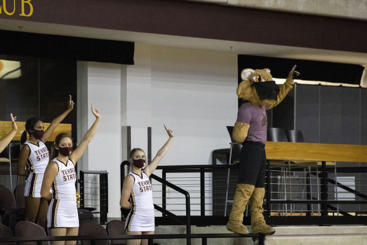 Boko the Bobcat holds up the Texas State hand sing along with the Texas State cheerleaders during a volleyball game against the University of Arkansas at Little Rock, Saturday, Oct. 24, 2020, at Strahan Arena. The Bobcats won 3-0 against the Trojans.
