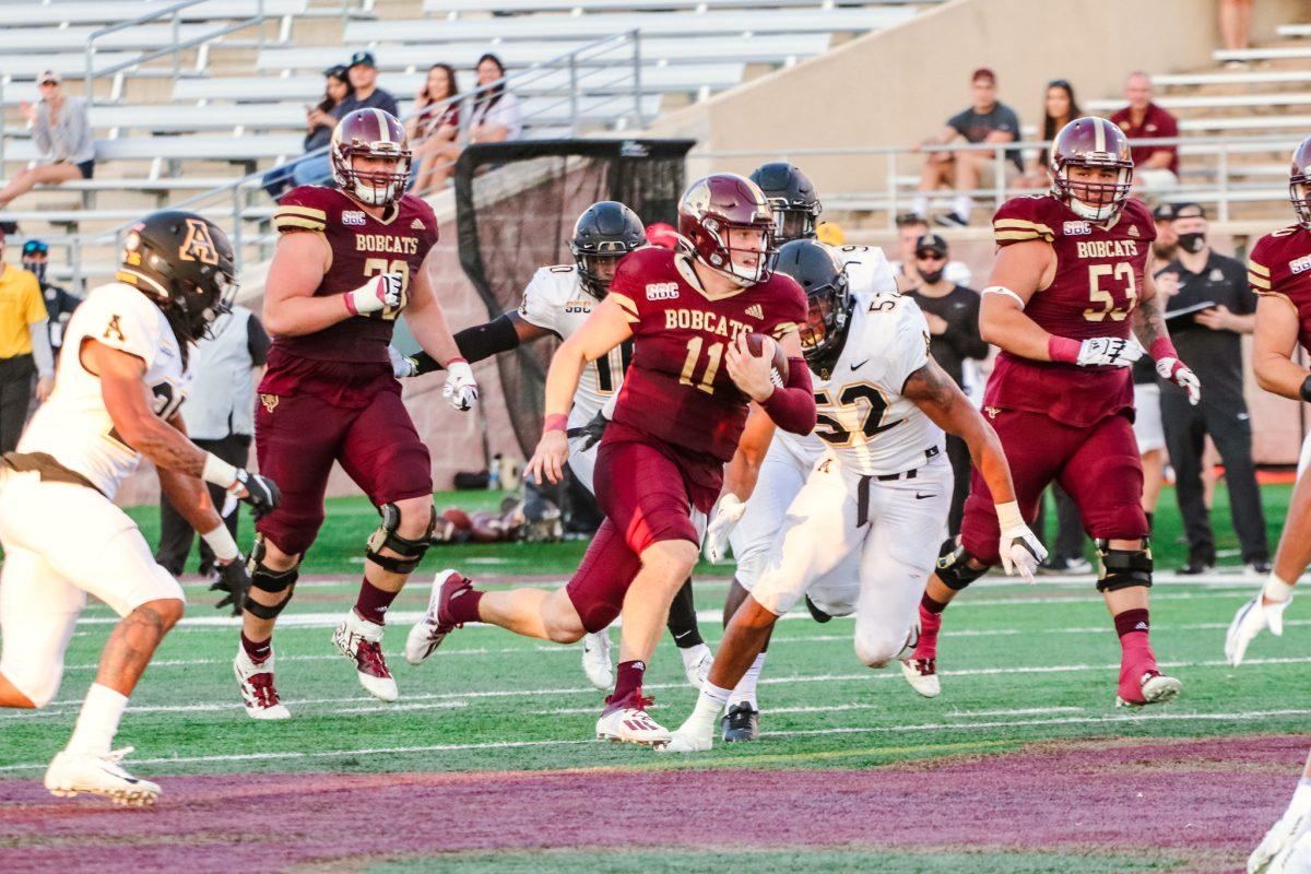 Texas State junior quarterback Tyler Vitt (11) carries the ball as he sprints up the field dodging Appalachian State University defenders, Saturday, Nov. 7, 2020, at Bobcat Stadium. The Bobcats lost 38-17.