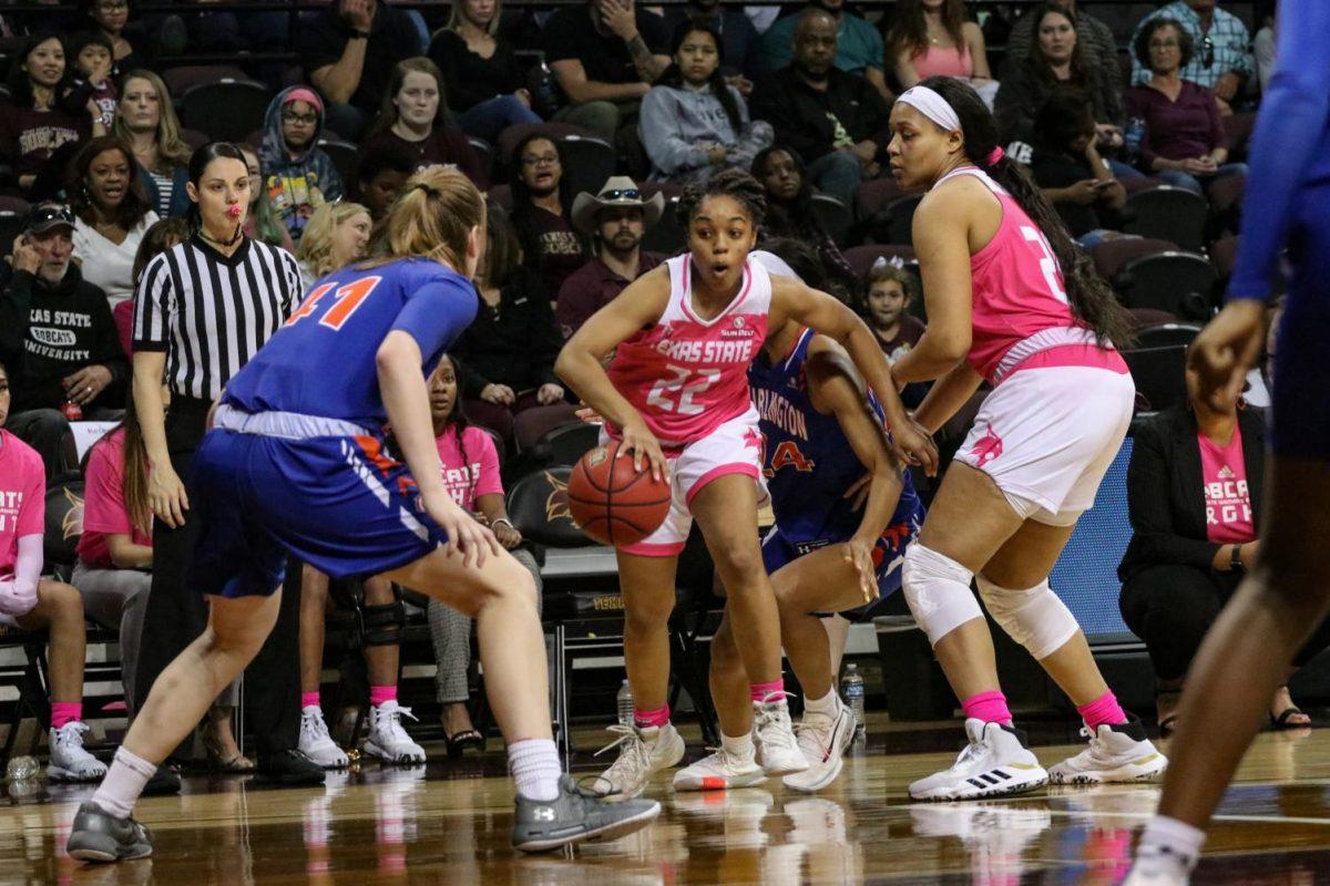 Texas State sophomore guard Kennedy Taylor, (22), dribbles a basketball around UTA sophomore guard Katie Ferrell in a matchup between the two teams, Saturday, Feb. 1, 2020, at Strahan Arena.