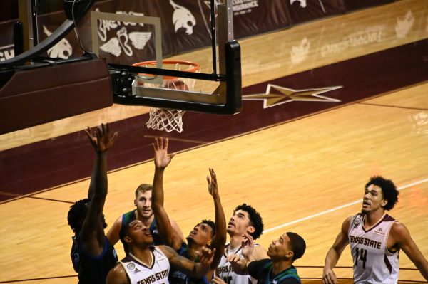 Players reach up to grab the ball which has bounced off the rim of the hoop, Tuesday, Dec. 15, 2020, at Strahan Arena. Texas State won the game 51 - 46.