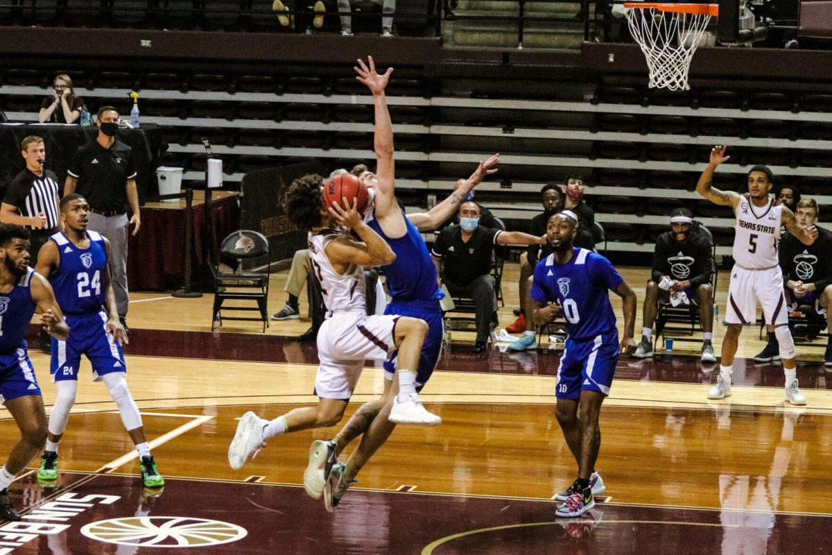 Texas State junior guard Mason Harrell (12) jumps towards the Bobcat basket in order to score against Our Lady of the Lake University, Saturday, Dec. 12, 2020, at Strahan Arena. The Bobcats lost 61-58.