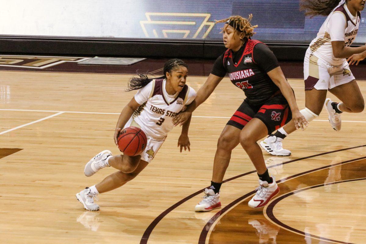Texas State junior guard Kennedy Taylor (3) dribbles the ball around a University of Louisiana at Lafayette defender, Friday, Jan. 1, 2021, at Strahan Arena. The Bobcats won 71-63.