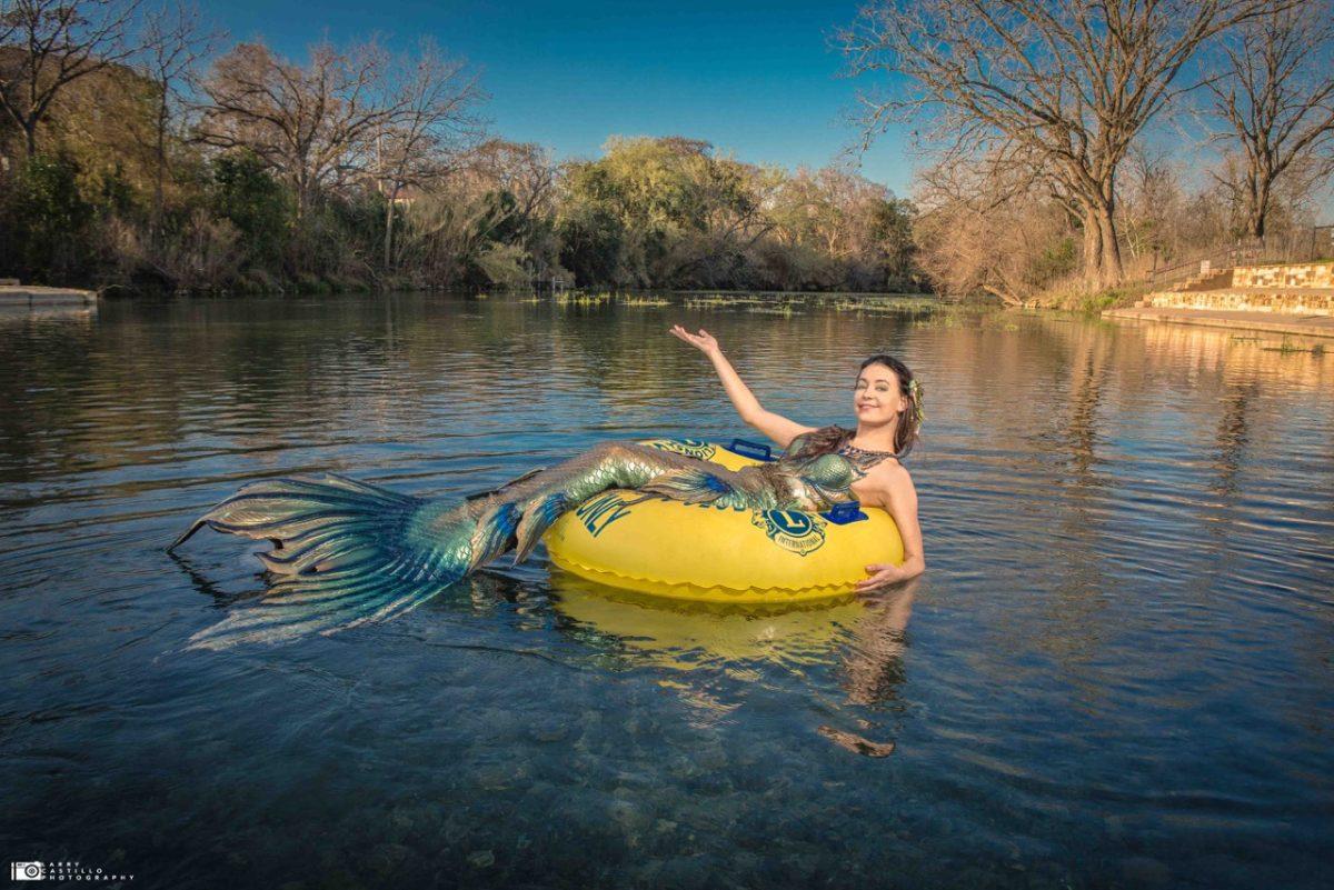 A woman dressed as a mermaid tubes along the San Marcos river.