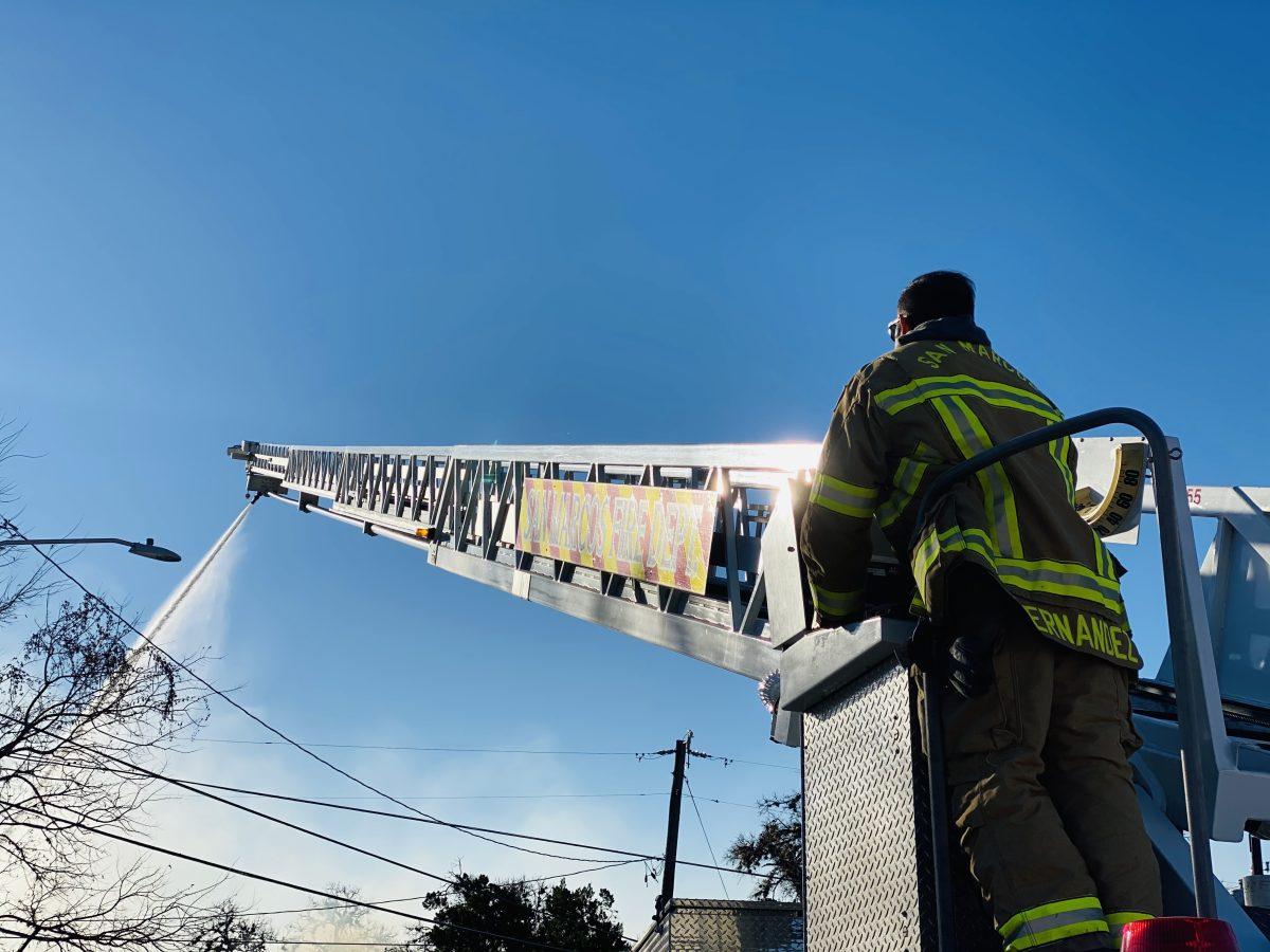 A San Marcos firefighter works to put out a flame on Monday, Feb. 22, 2021, at a house fire located at 421 Lindsey St.