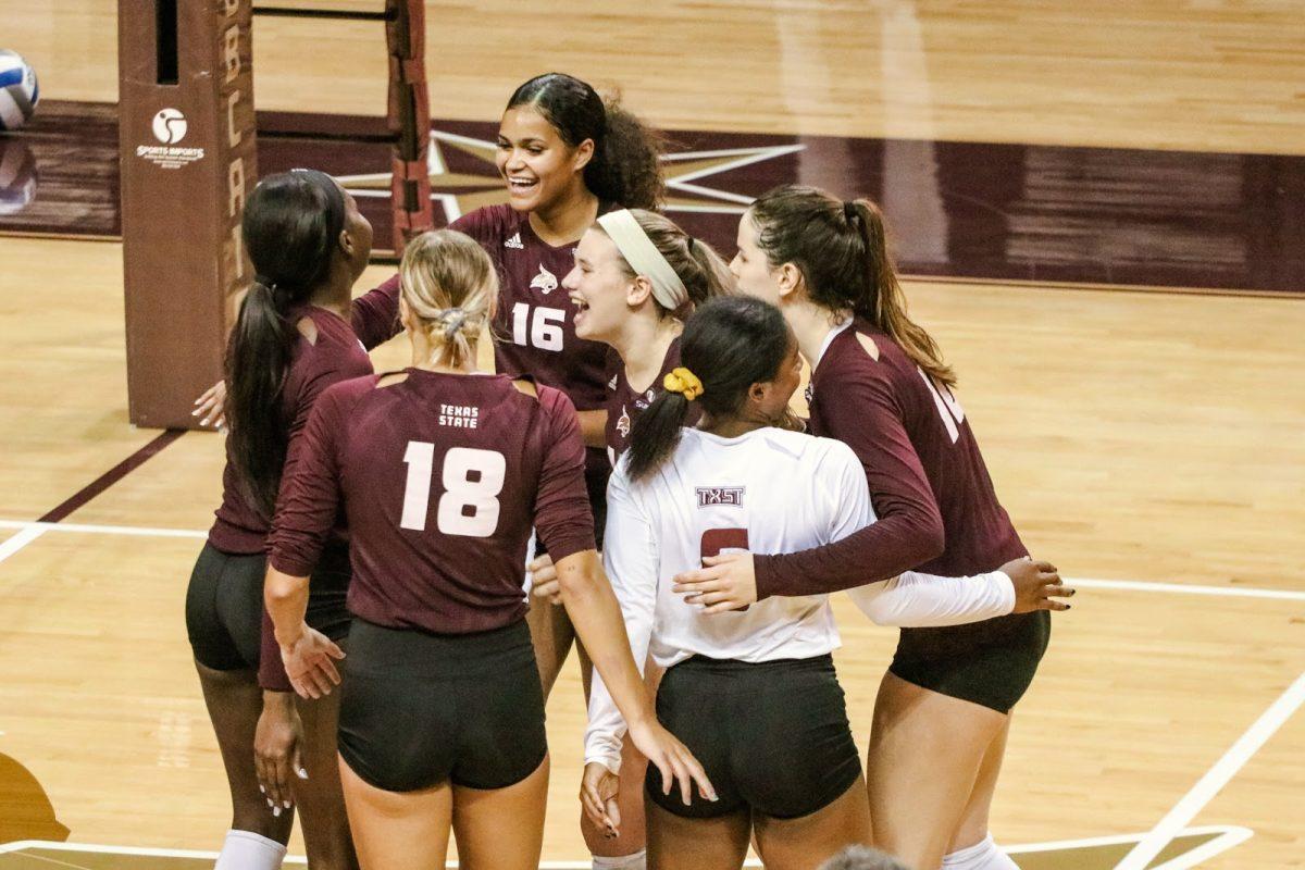 The Texas State volleyball team comes together in celebration after scoring a point during the match against the University of Louisiana at Lafayette on Oct. 17, 2020, at Strahan Arena. The Bobcats won 3-0.