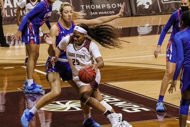 Texas State sophomore forward Lauryn Thompson (25) dribbles the ball around a Maverick defender to get in position to score, Friday, Feb. 12, 2021, at Strahan Arena. The Bobcats won 66-45.