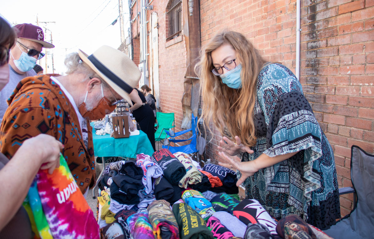 An owner of Bohemian Mamajamas Hannah Kocian sells clothing, Saturday, March 20, 2021, at The Unknown Concepts Back Alley Bazaar.