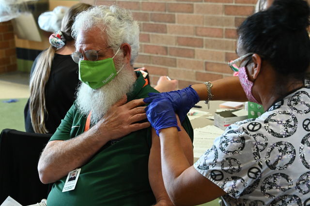 San Marcos Academy world geography teacher Harvey Manning (left) receives his COVID-19 vaccine from Eliza Herrera LVN (right), Friday, March 11, 2021, at San Marcos High School.