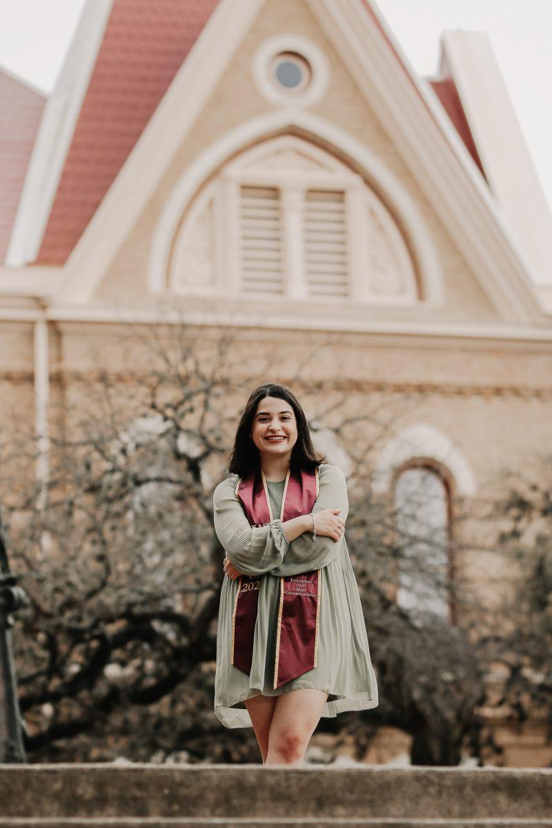 Gabriella Ybarra smiles for her graduation photos on Texas States Campus. 