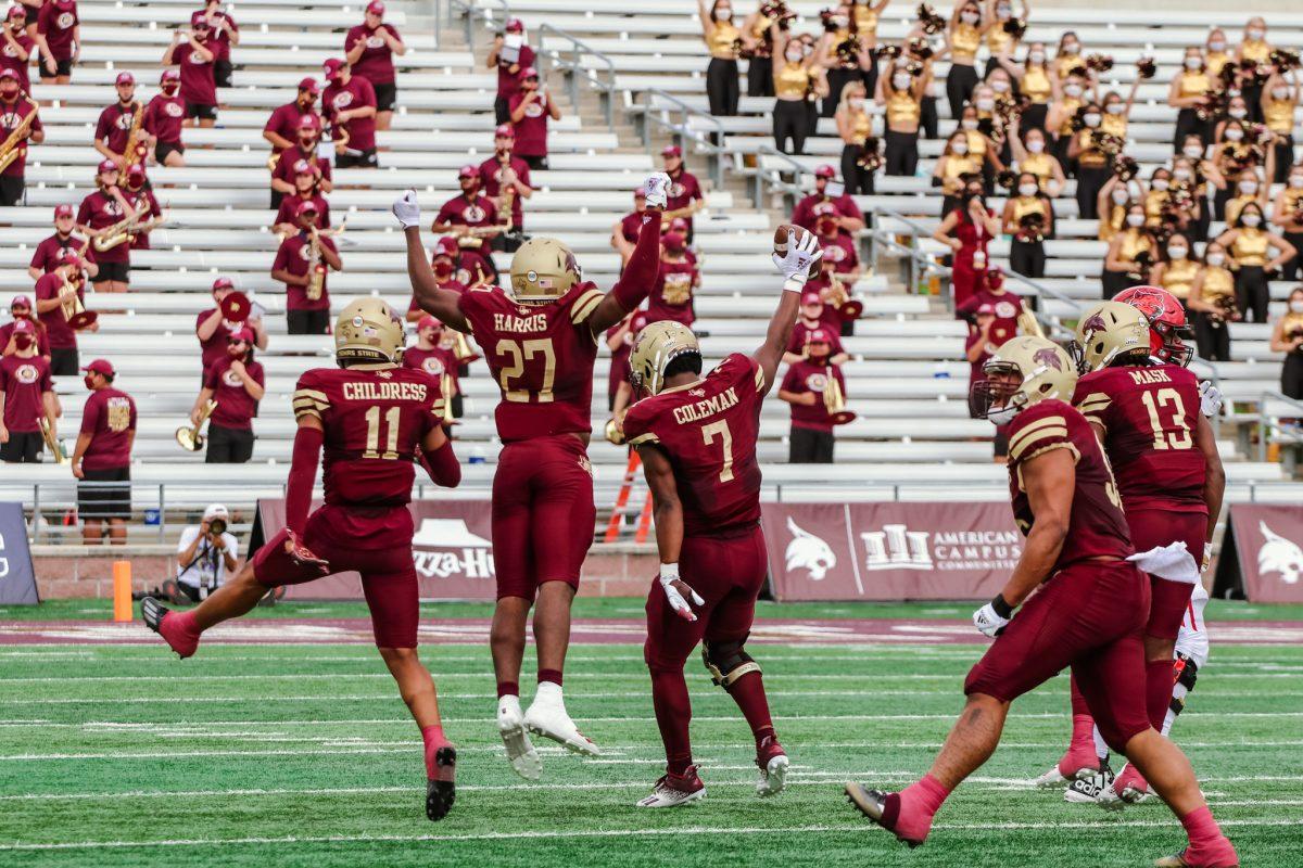 Texas State senior linebacker Markeveon Coleman (7) holds up the football after recovering a fumble from Arkansas State as players celebrate, Saturday, Nov. 21, 2020, at Bobcat Stadium. Texas State won 47-45.