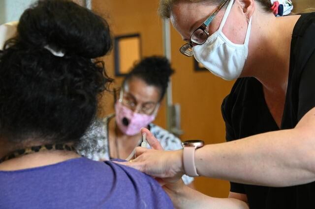 Nursing instructor Joy Hargraves LVN (right) administers a COVID-19 vaccine to San Marcos Academy Boarding Director Stephanie Ramirez (left), Friday, March 11, 2021, at San Marcos High School.